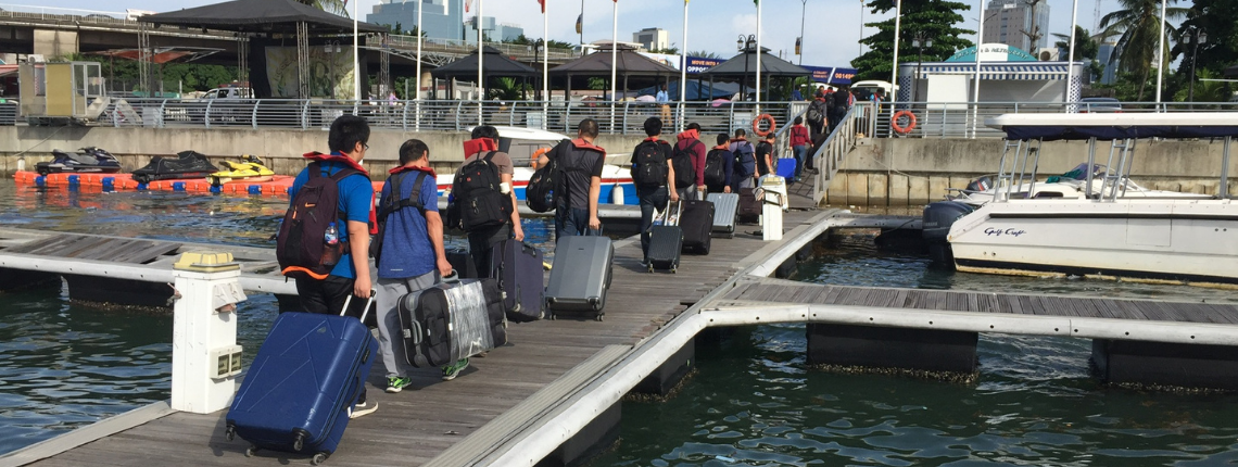 Members of ship crew disembarking with their suitcases