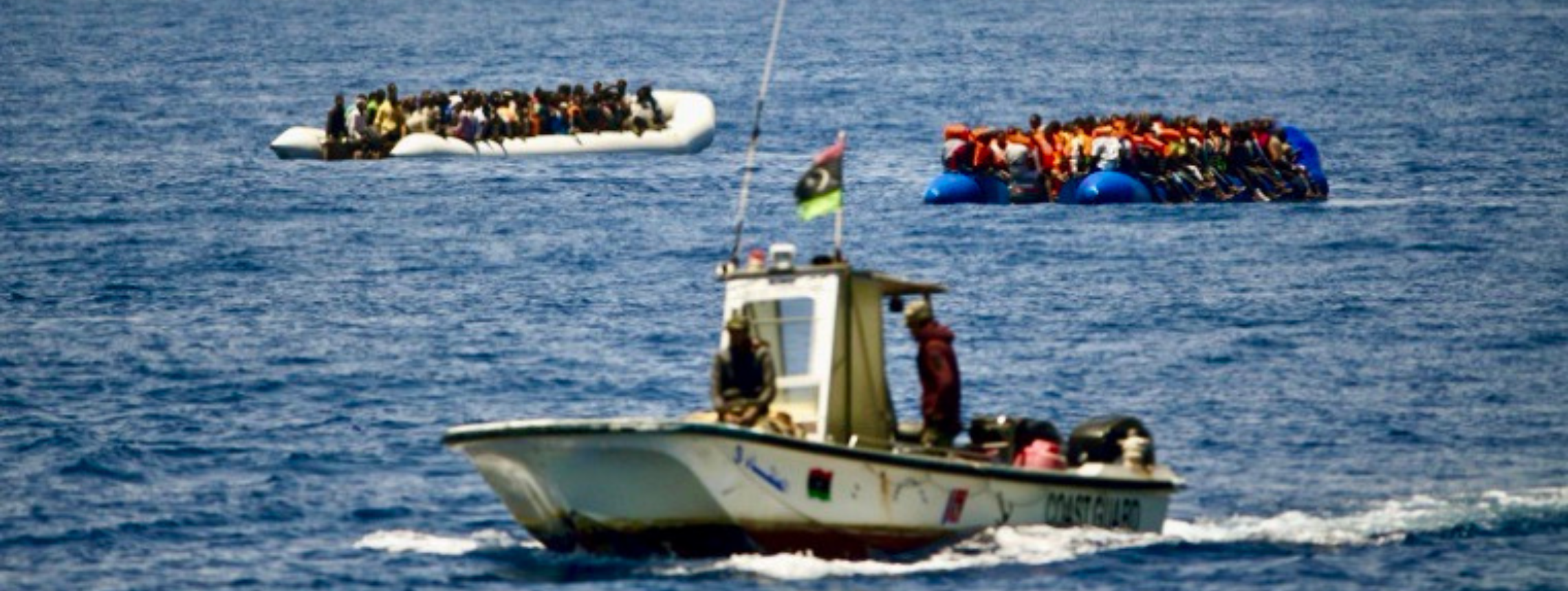 Libya Migrant Security A support boat and 2 rafts filled with people