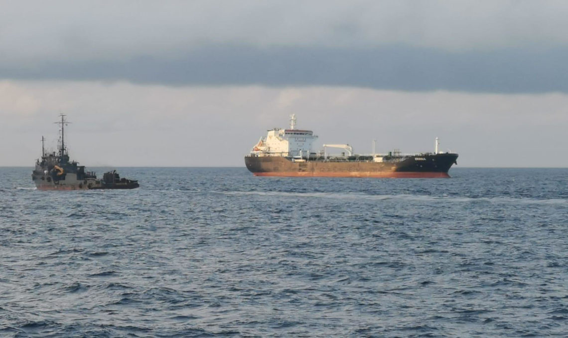 Security escort vehicle alongside a ship that has undergone vessel hardening.

